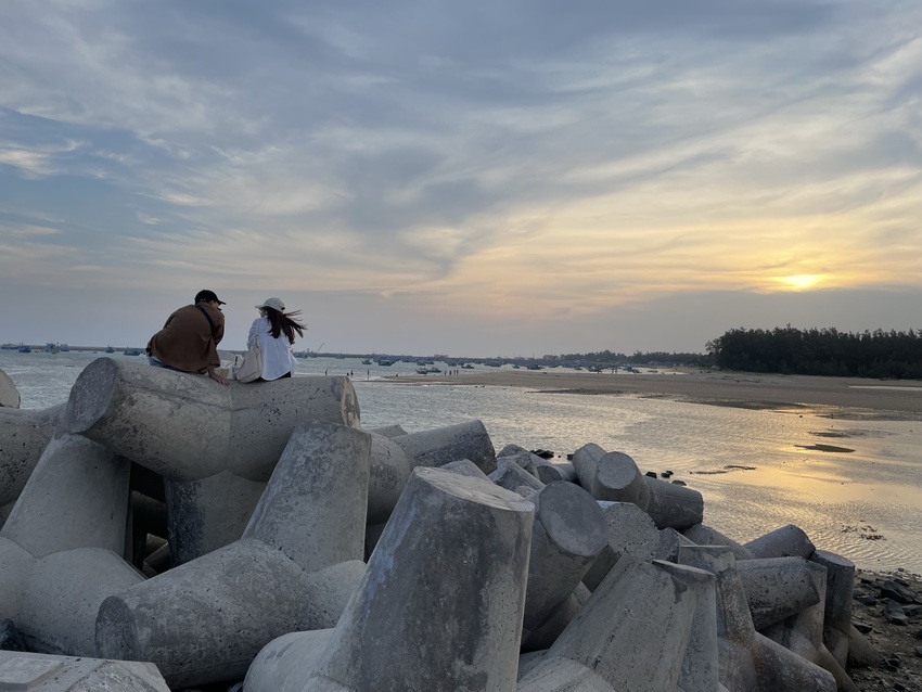 Khung cảnh hoàng hôn rọi bóng trên biển ở vịnh Triều Dương